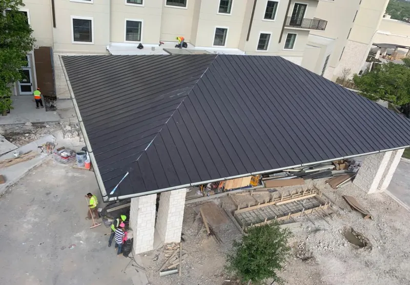 Metal roofing installation team working on a commercial building in San Benito